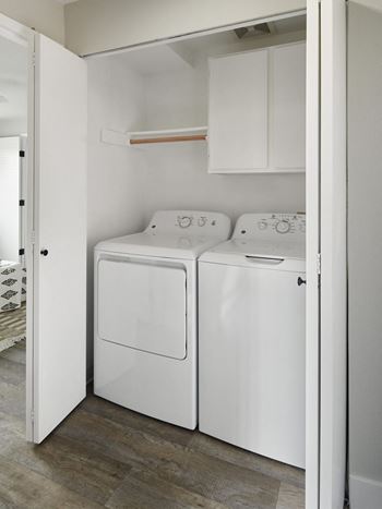 A white washing machine and dryer in a small laundry room.
